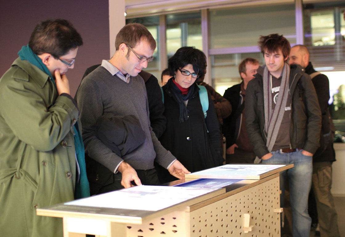 A group of people standing round the Arup table