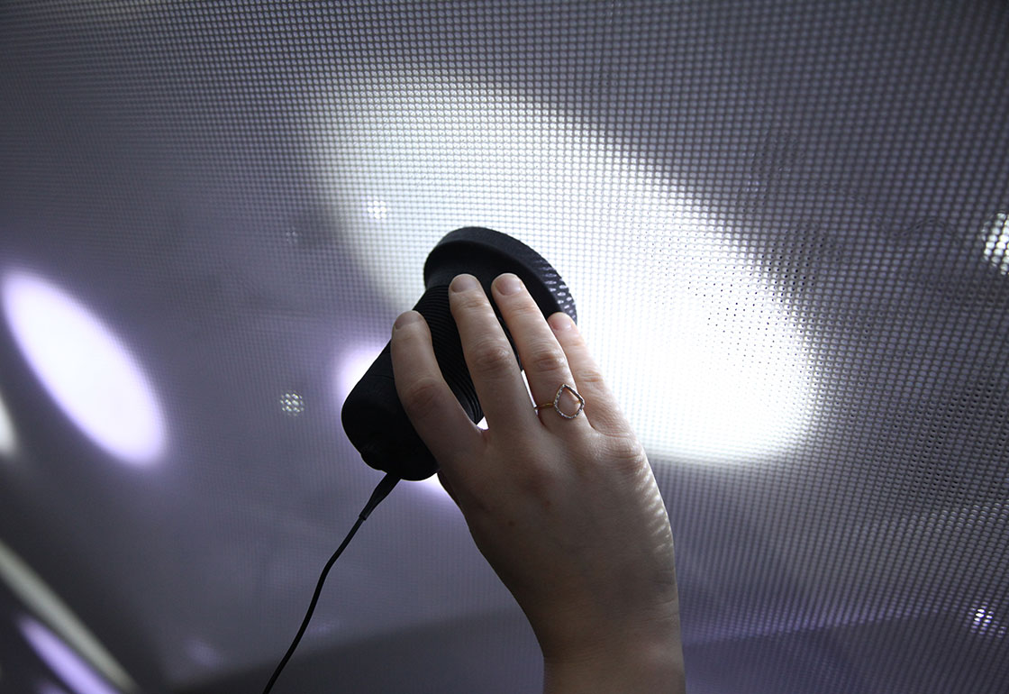 a hand holding a receiver to a pool of light