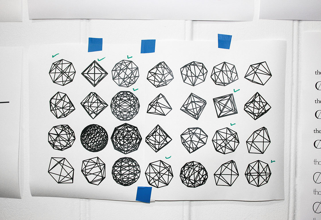 A page of 28 geometric shapes taped onto a wall
