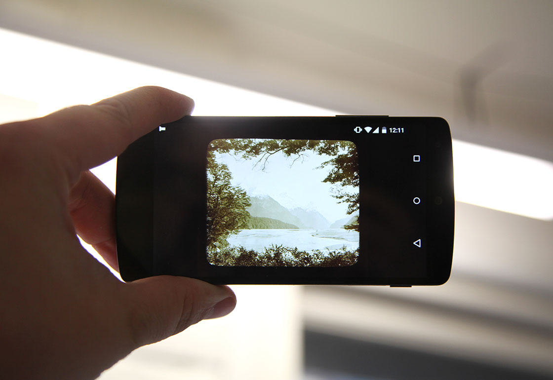 Lantern slide image on a smartphone being held up to a light